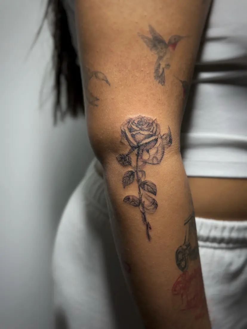 Black and grey rose tattoo on an arm