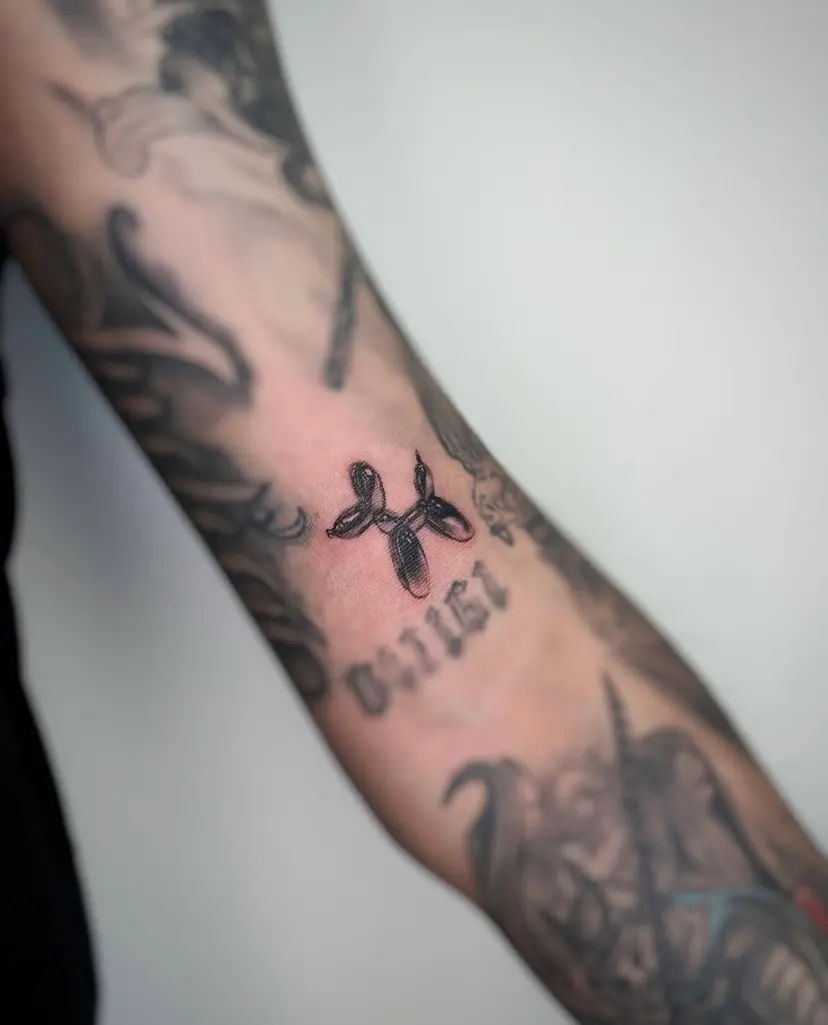 Balloon dog tattoo on an arm